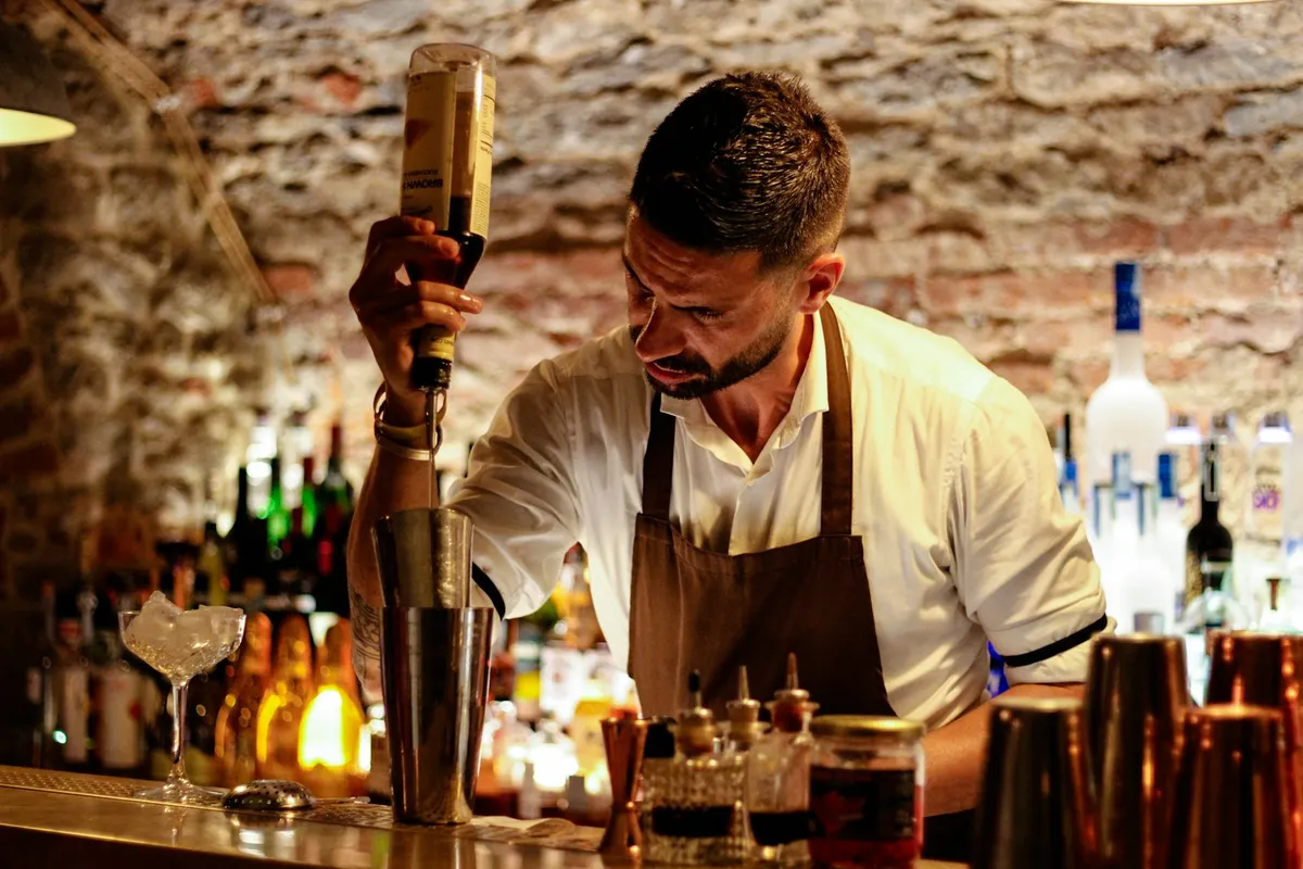 Bartender freelancer preparando um drink no bar
