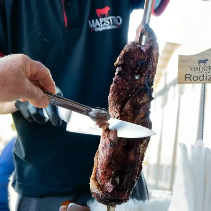 Churrasqueiro cortando a picanha no espeto