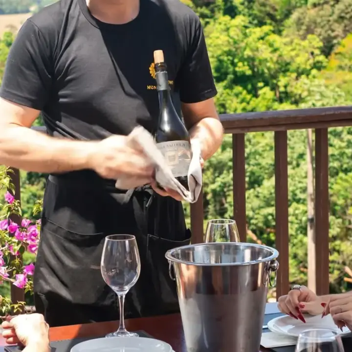 Garçom servindo vinho na mesa